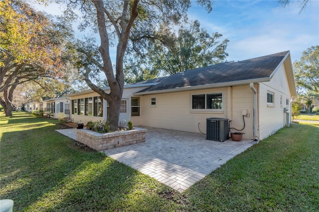 back of property featuring a yard, central AC, and a patio area