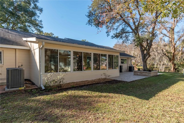 rear view of house featuring a lawn, central AC, and a patio