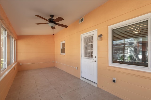 unfurnished sunroom featuring ceiling fan and vaulted ceiling