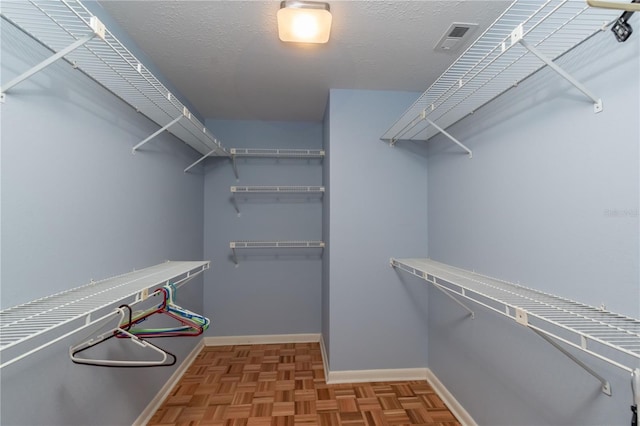 spacious closet with light parquet floors