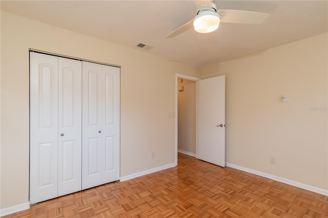 unfurnished bedroom featuring ceiling fan, a closet, and light parquet flooring