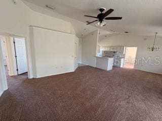 unfurnished living room featuring dark colored carpet, ceiling fan with notable chandelier, and lofted ceiling