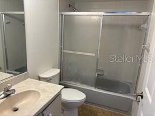 full bathroom with vanity, toilet, and enclosed tub / shower combo