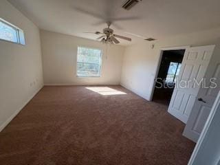 carpeted spare room featuring ceiling fan