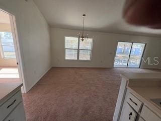 unfurnished dining area with light colored carpet and an inviting chandelier