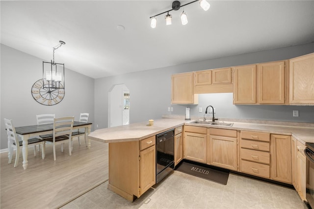 kitchen featuring kitchen peninsula, light brown cabinetry, hanging light fixtures, and sink