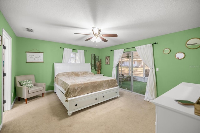 bedroom featuring access to exterior, light carpet, a textured ceiling, and ceiling fan