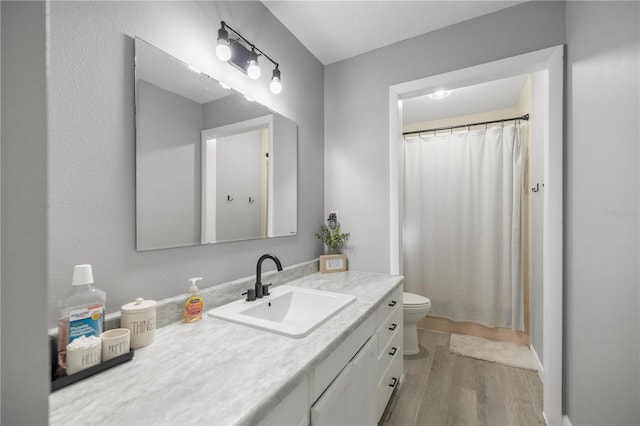 bathroom with vanity, hardwood / wood-style flooring, and toilet