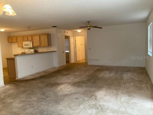 unfurnished living room featuring a textured ceiling, ceiling fan, and carpet