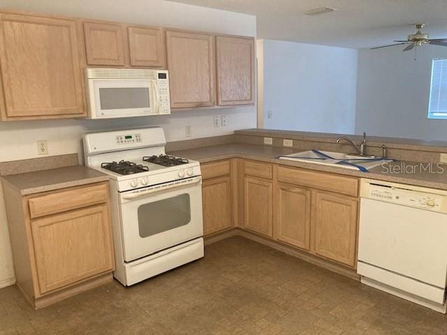 kitchen with light brown cabinetry, sink, and white appliances