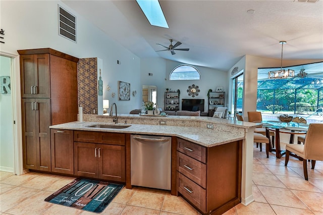 kitchen featuring light tile patterned flooring, decorative light fixtures, sink, stainless steel dishwasher, and light stone counters