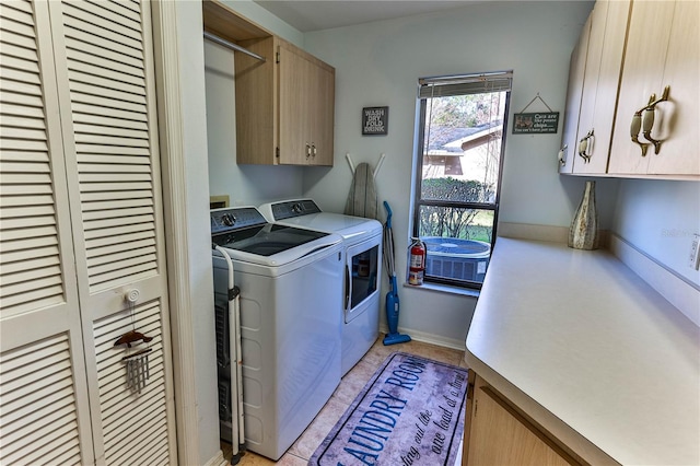 washroom with cabinets and washing machine and clothes dryer