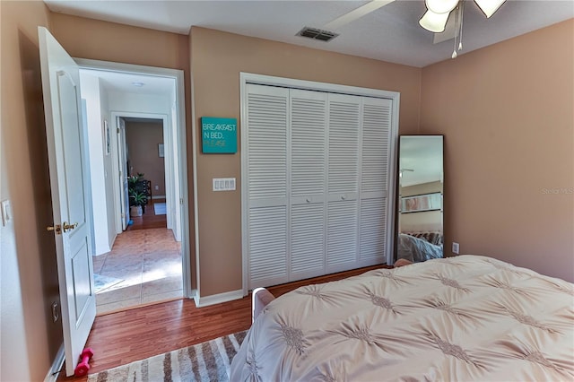 bedroom with hardwood / wood-style floors, a closet, and ceiling fan