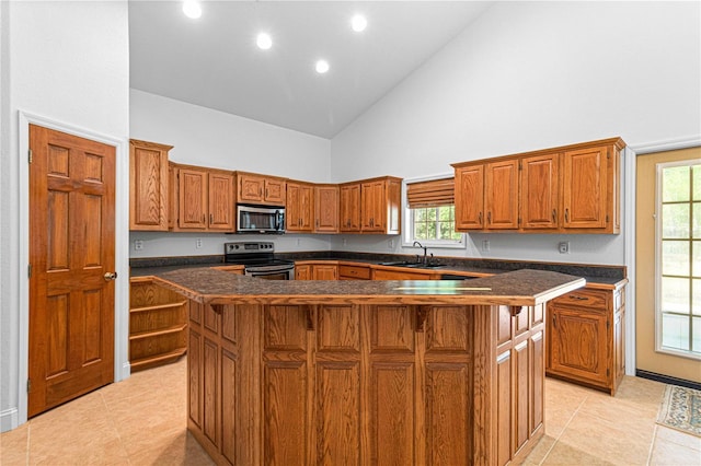 kitchen featuring appliances with stainless steel finishes, sink, high vaulted ceiling, a center island, and light tile patterned flooring