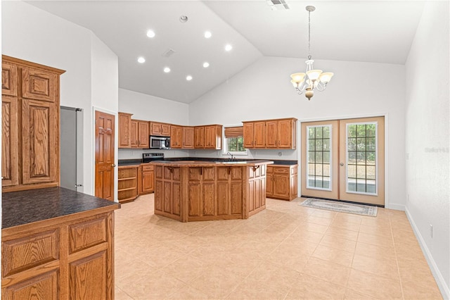 kitchen featuring french doors, an inviting chandelier, high vaulted ceiling, decorative light fixtures, and a kitchen island