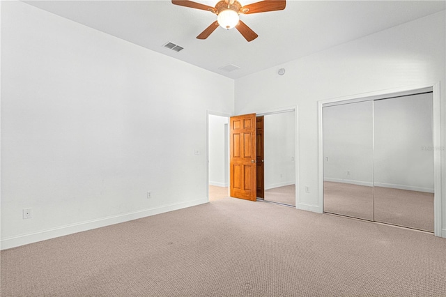 unfurnished bedroom featuring ceiling fan, carpet, and two closets