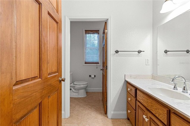 bathroom featuring tile patterned flooring, vanity, and toilet