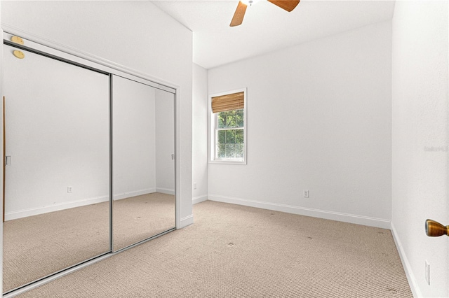 unfurnished bedroom featuring ceiling fan, a closet, and light colored carpet