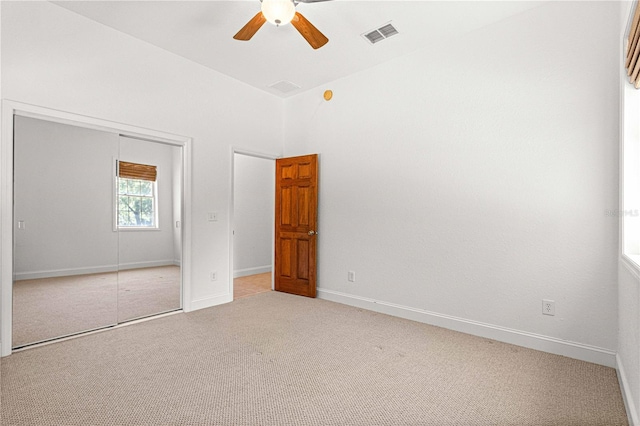 unfurnished bedroom with carpet flooring, ceiling fan, and a closet