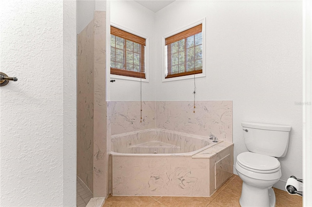 bathroom with tile patterned flooring, toilet, and a tub