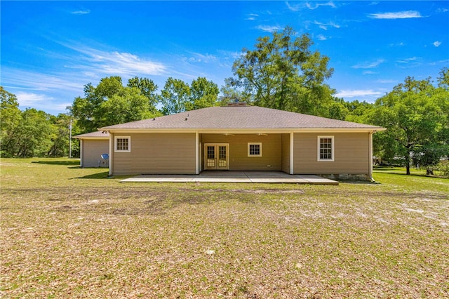 back of property with a patio area and a yard