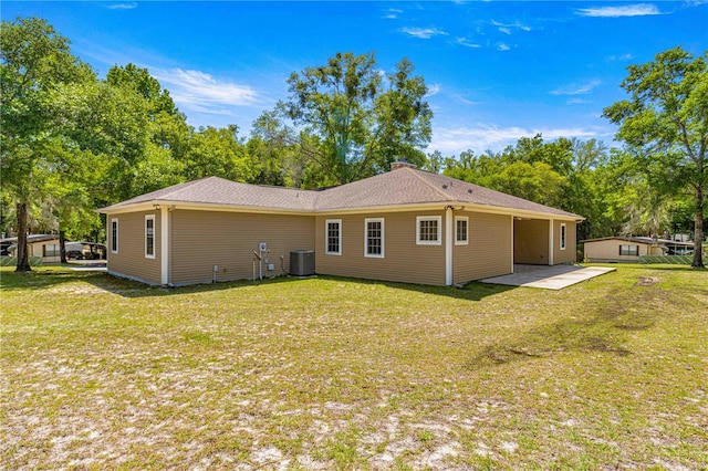 rear view of property with a lawn, central AC, and a patio