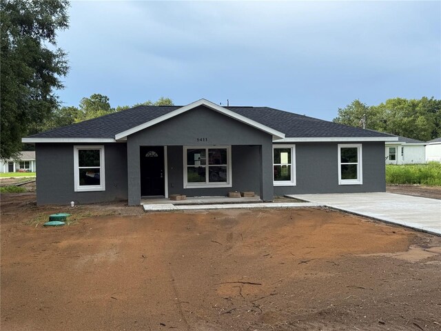 5411 NW 7th Pl, Ocala, FL 34482 - single story home featuring stucco siding, a porch, and a shingled roof