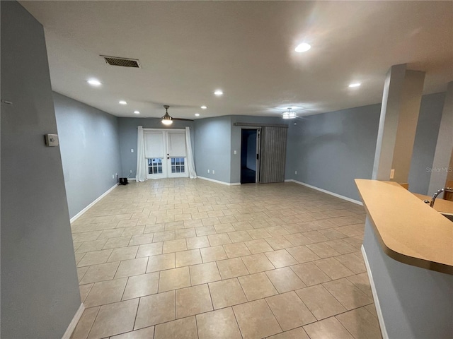 basement featuring french doors and light tile patterned flooring