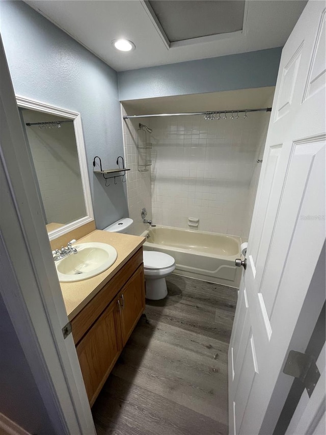 full bathroom with vanity, hardwood / wood-style flooring, toilet, and tiled shower / bath combo