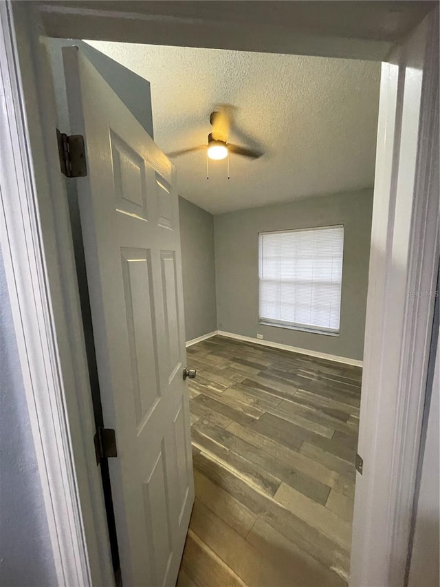 spare room with ceiling fan, dark hardwood / wood-style flooring, and a textured ceiling