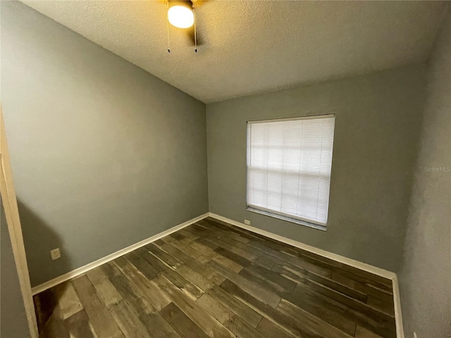 spare room featuring ceiling fan, dark hardwood / wood-style flooring, and a textured ceiling