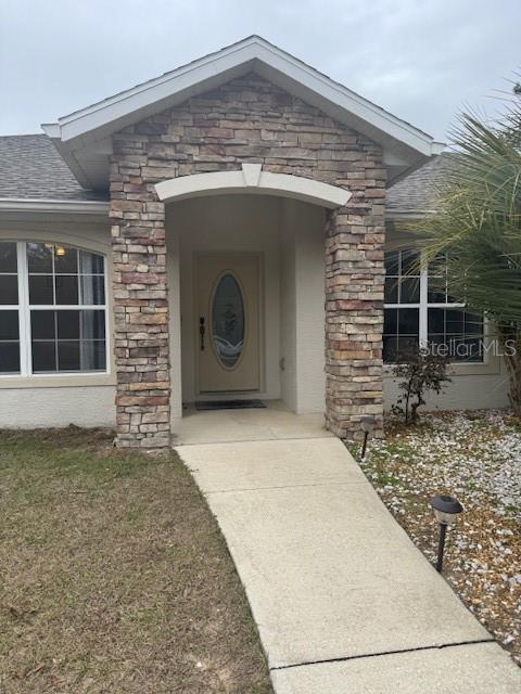 entrance to property featuring a yard