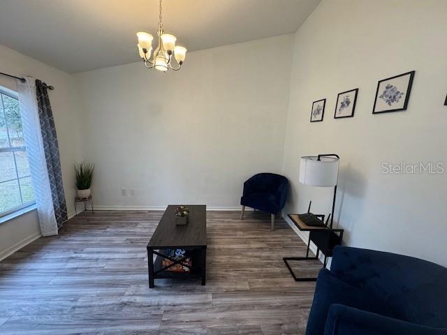 sitting room featuring a chandelier and wood-type flooring