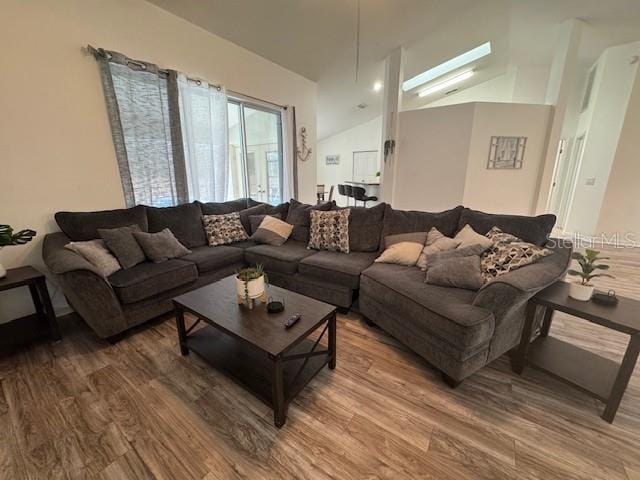 living room with vaulted ceiling and hardwood / wood-style flooring