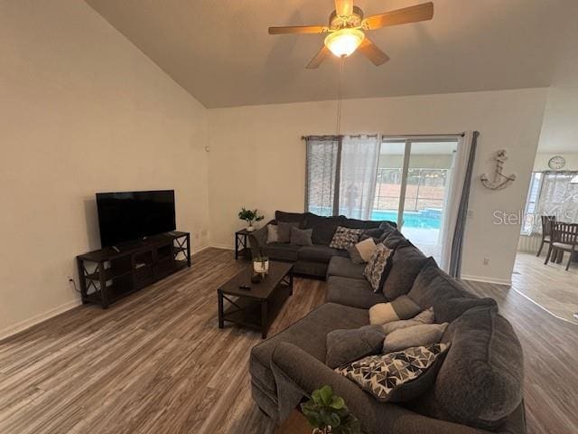 living room with ceiling fan, lofted ceiling, and hardwood / wood-style floors