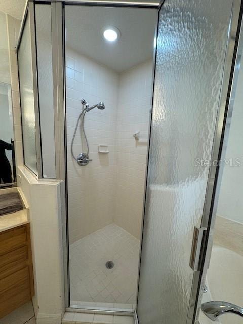 bathroom featuring vanity, tile patterned flooring, and walk in shower