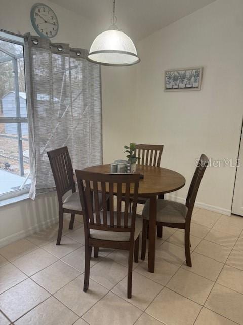 dining area with vaulted ceiling and light tile patterned floors