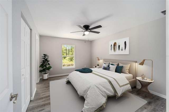 bedroom with hardwood / wood-style flooring, ceiling fan, and a closet