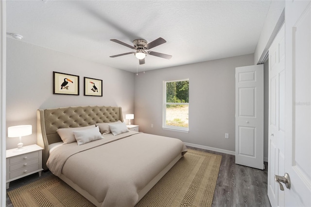 bedroom featuring ceiling fan, dark hardwood / wood-style floors, a textured ceiling, and a closet