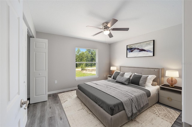 bedroom with ceiling fan, a closet, and hardwood / wood-style flooring