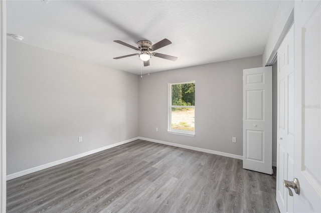 unfurnished bedroom featuring hardwood / wood-style floors, ceiling fan, and a textured ceiling