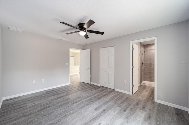 unfurnished bedroom featuring light hardwood / wood-style floors, ensuite bath, and ceiling fan