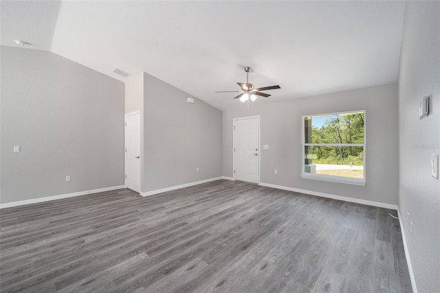 empty room with dark hardwood / wood-style floors, ceiling fan, and vaulted ceiling