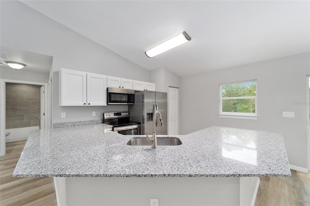 kitchen with kitchen peninsula, light stone counters, white cabinets, and stainless steel appliances