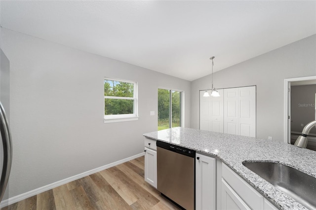 kitchen with sink, hanging light fixtures, vaulted ceiling, stainless steel dishwasher, and white cabinetry