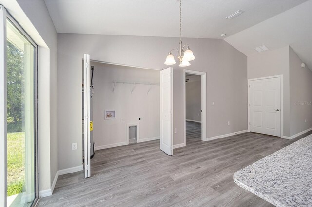 dining space featuring light hardwood / wood-style flooring, vaulted ceiling, and an inviting chandelier