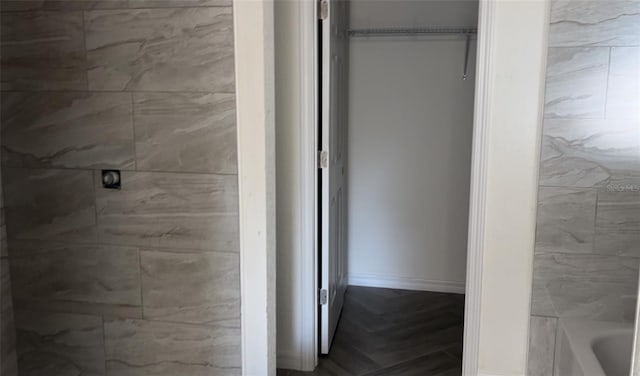 bathroom featuring parquet flooring and a tub to relax in