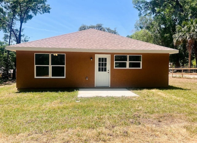 13253 SE 35th Ct, Belleview, FL 34420 - rear view of house with a patio, a yard, stucco siding, and roof with shingles