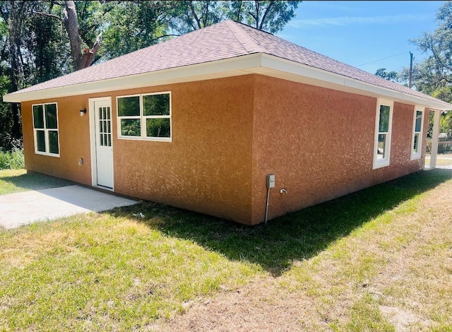 13253 SE 35th Ct, Belleview, FL 34420 - view of home's exterior with a lawn, a shingled roof, and stucco siding