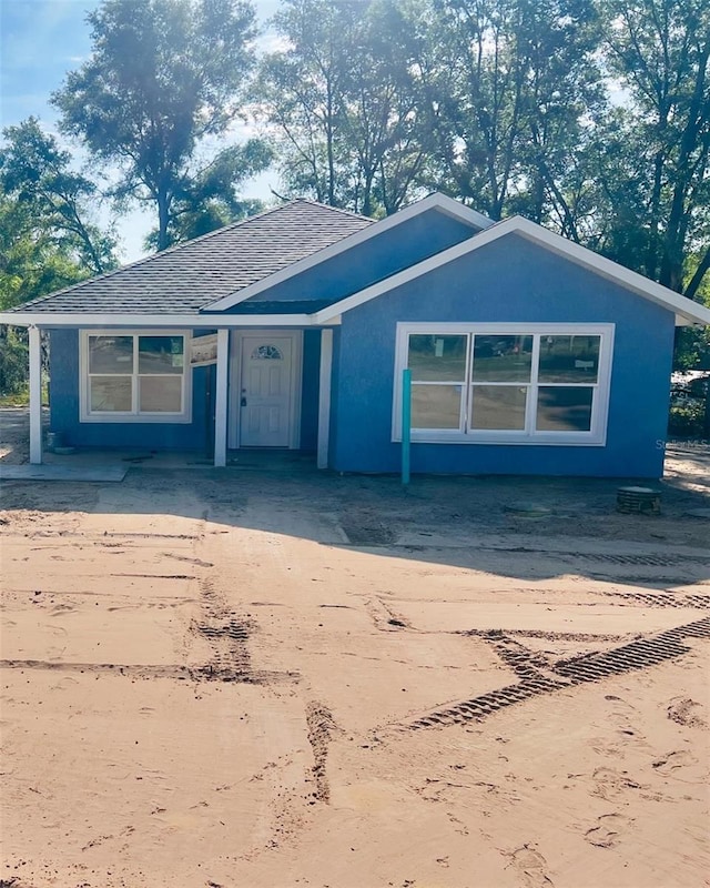 view of front of home with a shingled roof and concrete driveway